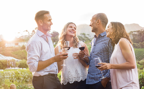 Two couples drink Edenvale wine in front of an Australian vineyard.