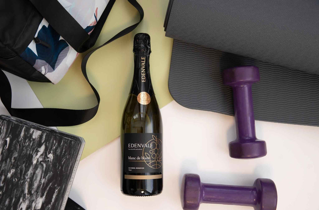 Bottle of Edenvale Blanc de Blanc lying alongside a gym bag and purple dumbbell