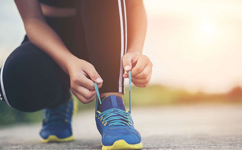 A person tying their shoelace
