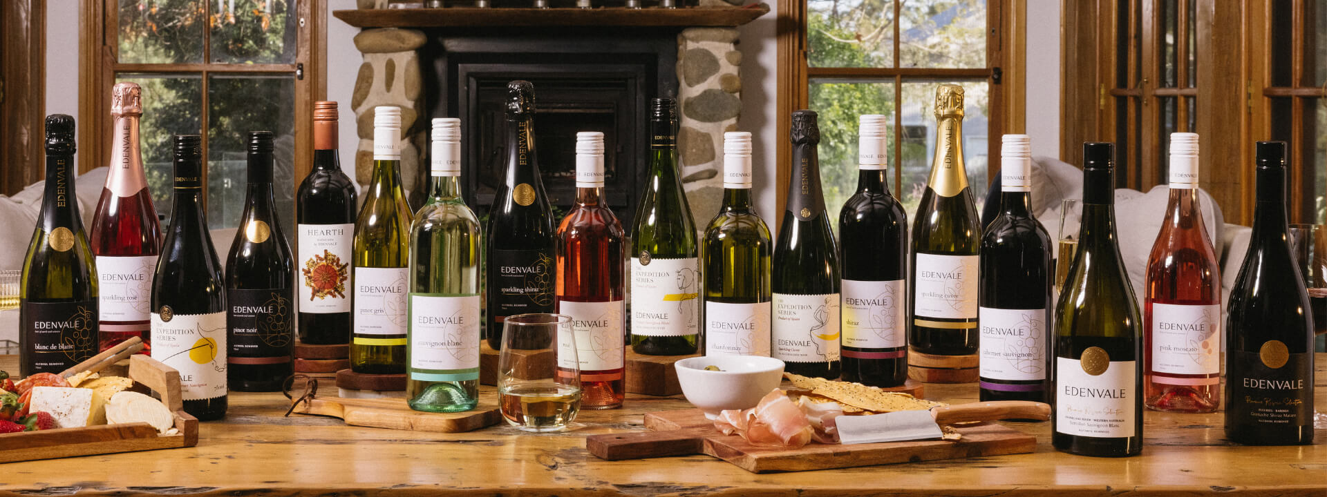 Various bottles of Edenvale wines, including non-alcoholic Rose, on a table with a platter of ham and crispbreads.