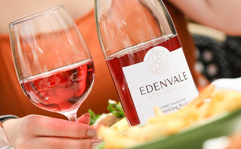 Bottle and glass of Edenvale alcohol-removed Rosé wine on a table with food during outdoor dining