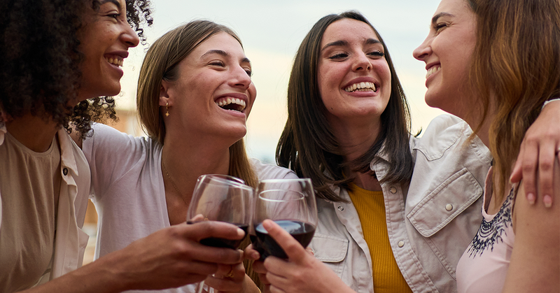 Friends raising a toast with non-alcoholic red wine in summer