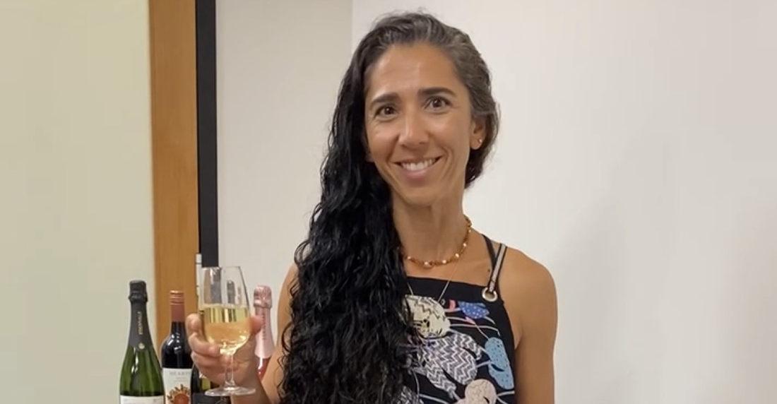 Edenvale Production and Operations Manager, Nina, holding a glass of non-alcoholic Sauvignon Blanc and smiling at camera
