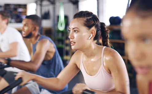 Woman in sports top participating in indoor cycling session