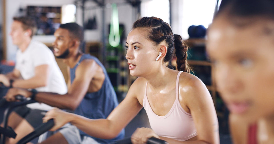 Woman in sports top participating in indoor cycling session