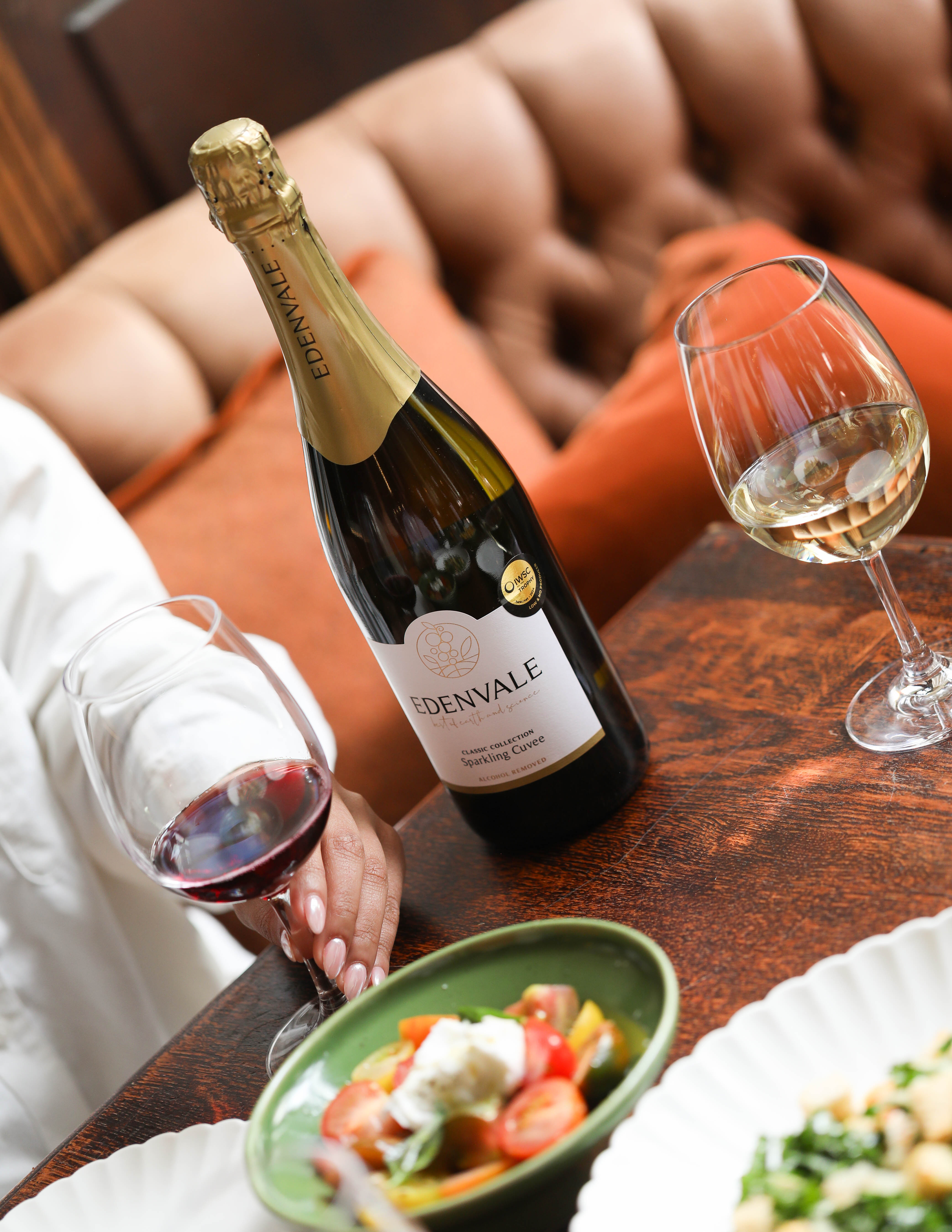 Bottle of Edenvale Sparkling Cuvee and two glasses with a bowl of fresh mixed cherry tomatoes with feta.