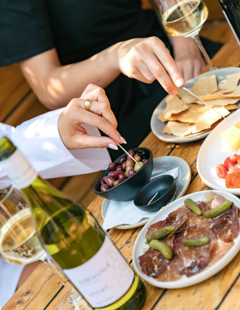  Edenvale Non-Alcoholic white wine bottle alongside a grazing board with olives, cured meats and flatbread crackers
